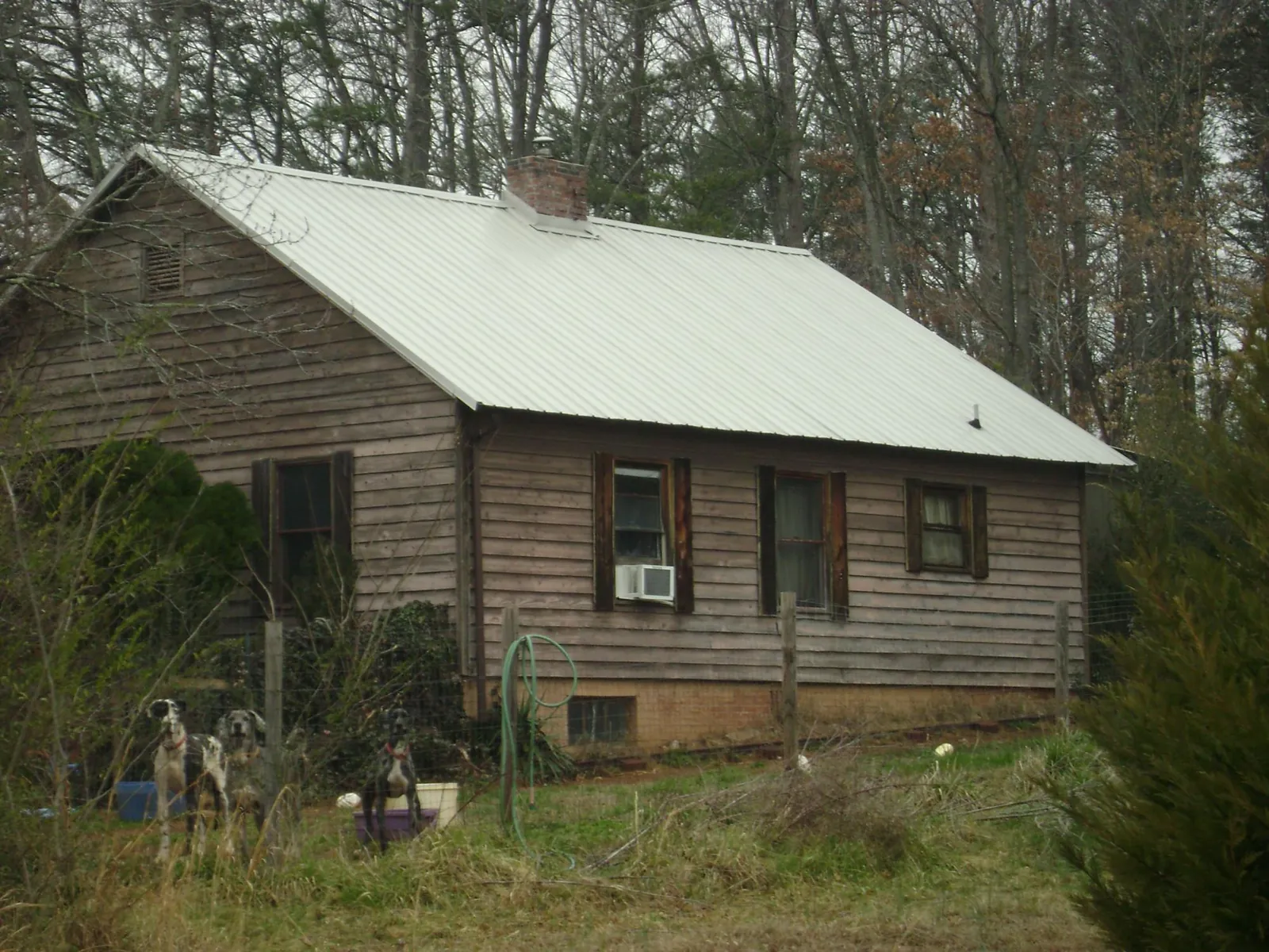 White metal roof on an old wood sided farmhouse, from a Metal Roof Installation job in Adams